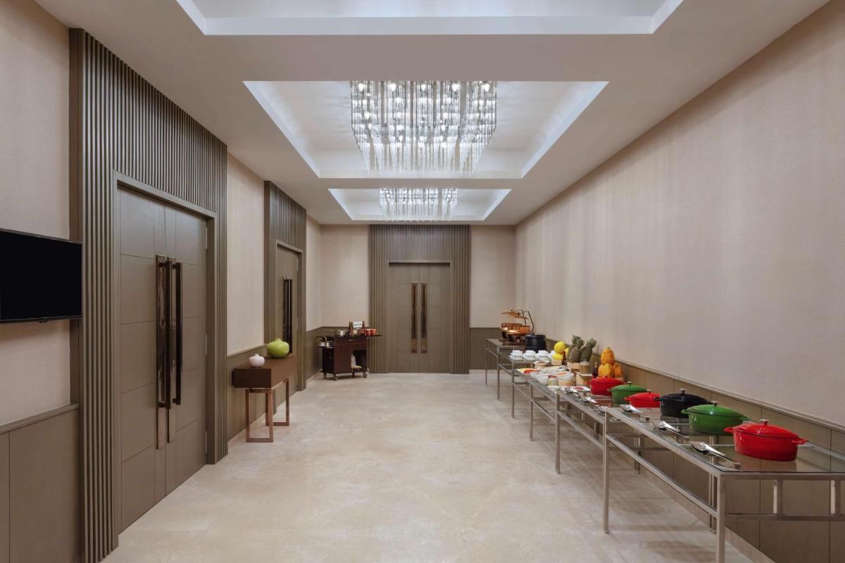 a long hallway with tables with food on them at DoubleTree By Hilton Jaipur Amer in Jaipur