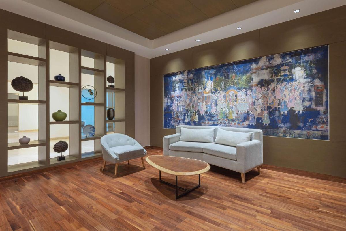 a living room with a couch and a painting on the wall at DoubleTree By Hilton Jaipur Amer in Jaipur