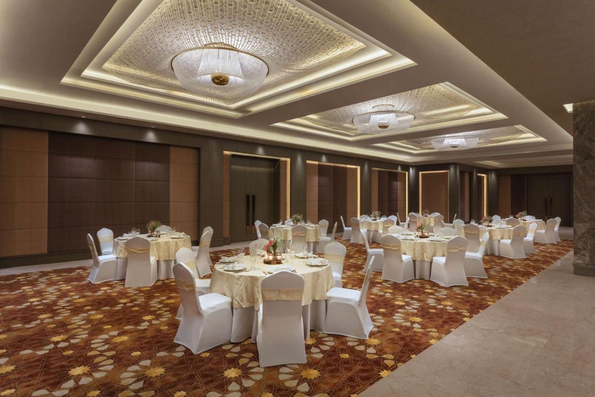 a banquet hall with white tables and white chairs at DoubleTree By Hilton Jaipur Amer in Jaipur