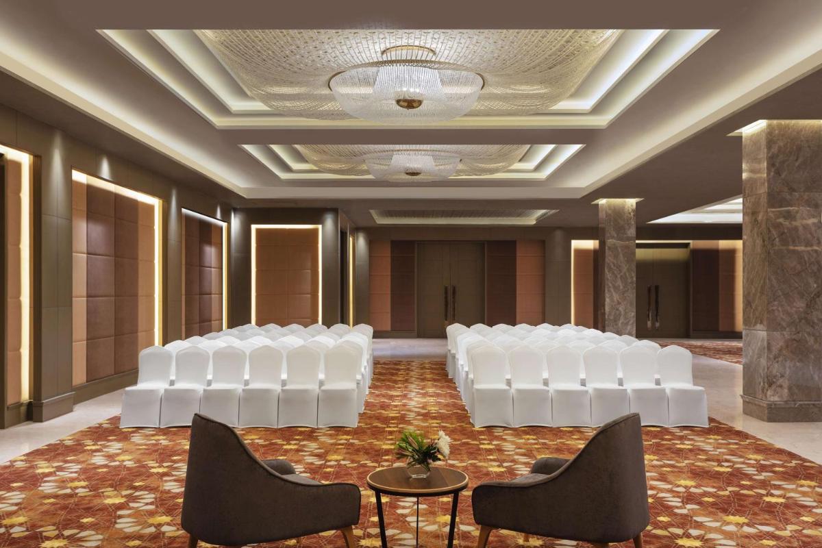 a room with a row of white chairs and a stage at DoubleTree By Hilton Jaipur Amer in Jaipur