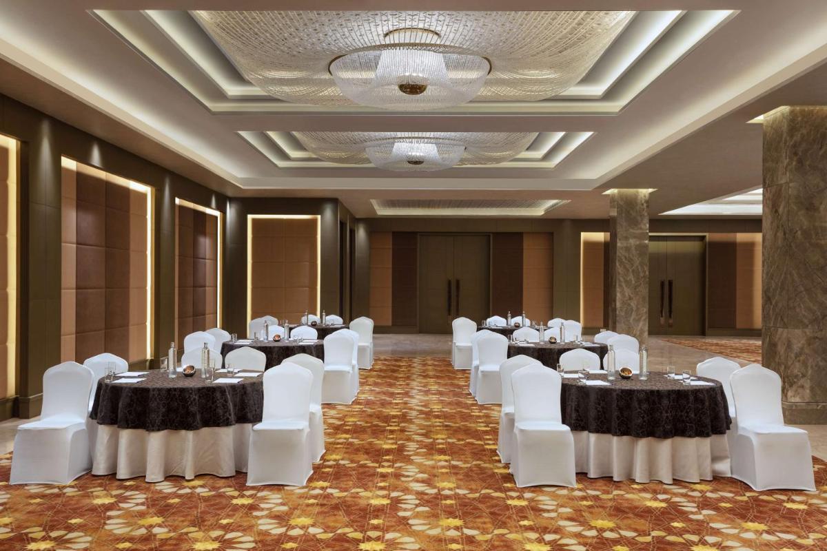 a banquet hall with white tables and white chairs at DoubleTree By Hilton Jaipur Amer in Jaipur