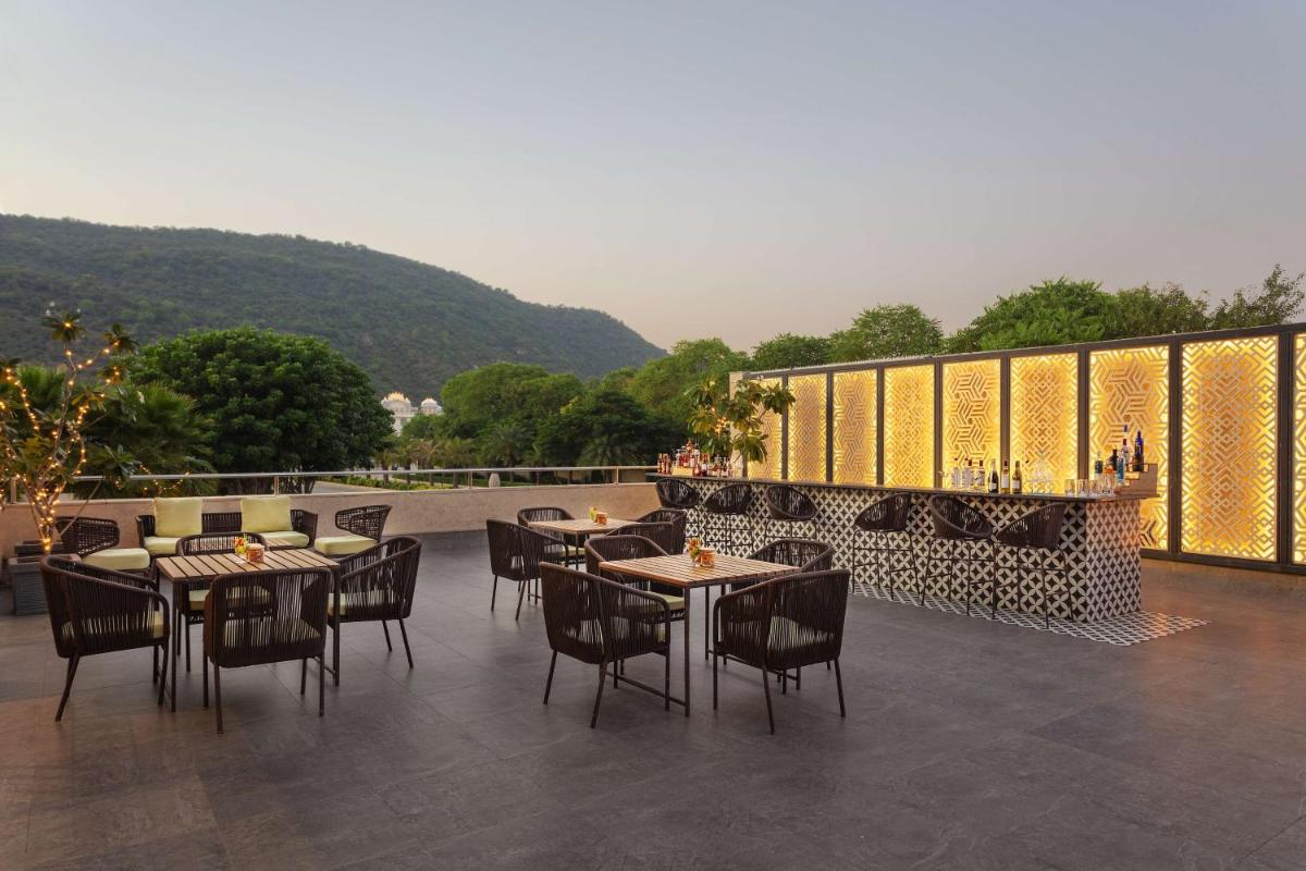 a restaurant with tables and chairs on a patio at DoubleTree By Hilton Jaipur Amer in Jaipur