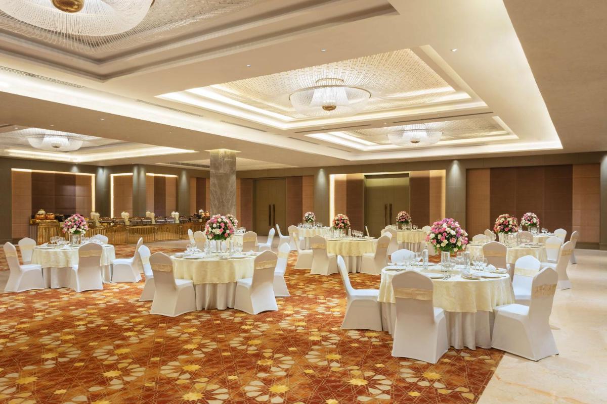 a banquet hall with white tables and white chairs at DoubleTree By Hilton Jaipur Amer in Jaipur