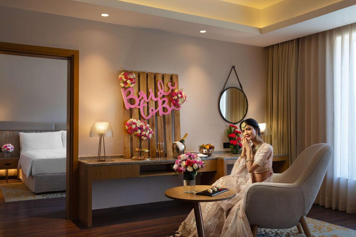 a woman sitting in a chair in a hotel room at DoubleTree By Hilton Jaipur Amer in Jaipur