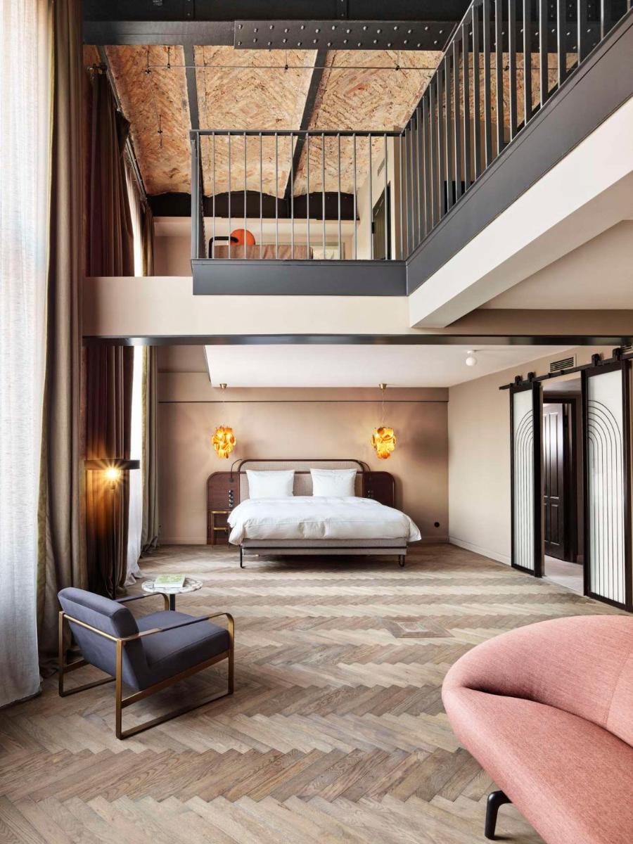 ein Hotelzimmer mit einem Bett und einer Treppe in der Unterkunft Telegraphenamt in Berlin