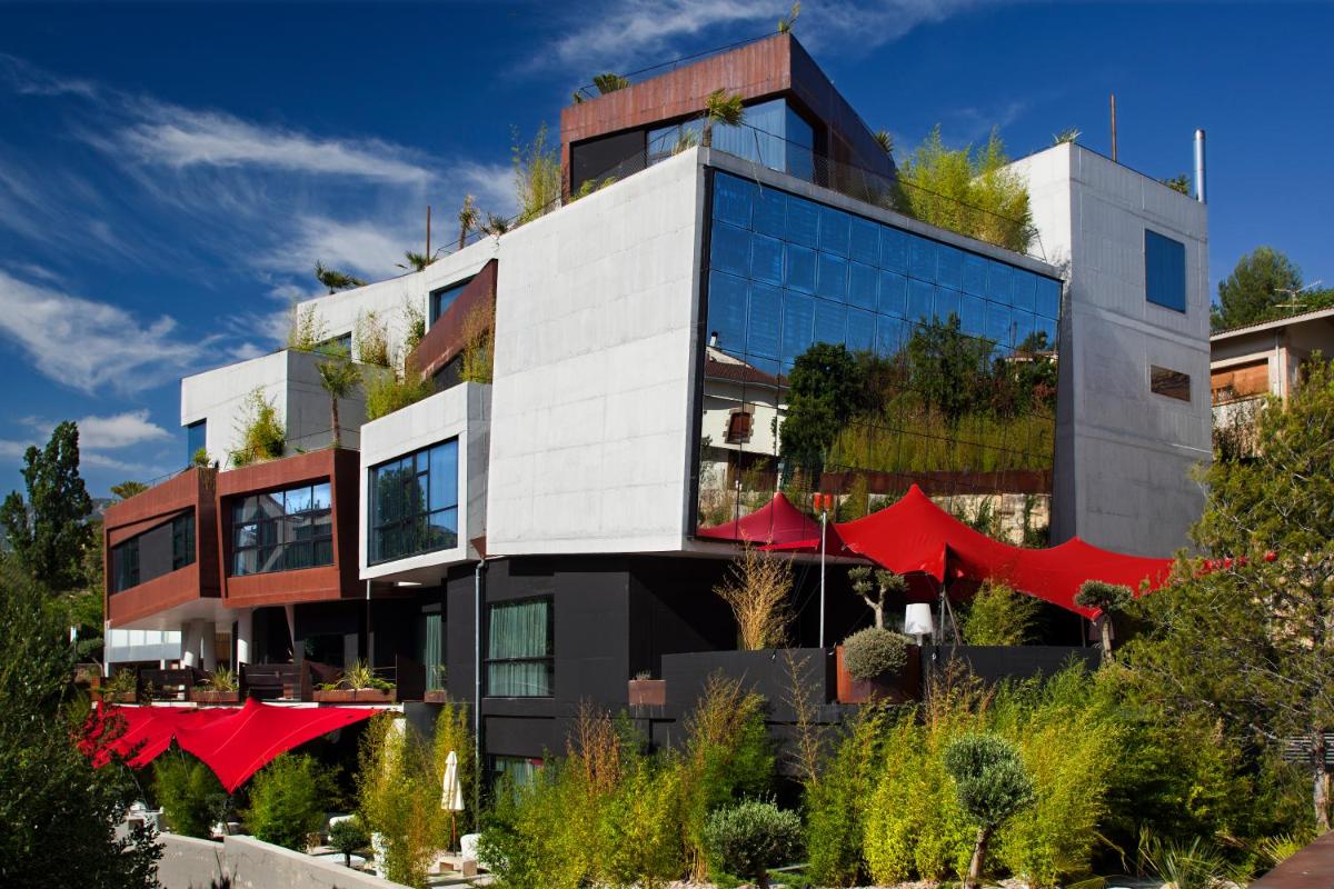 un gran edificio con arcos rojos delante de él en Hotel Viura, en Villabuena de Álava