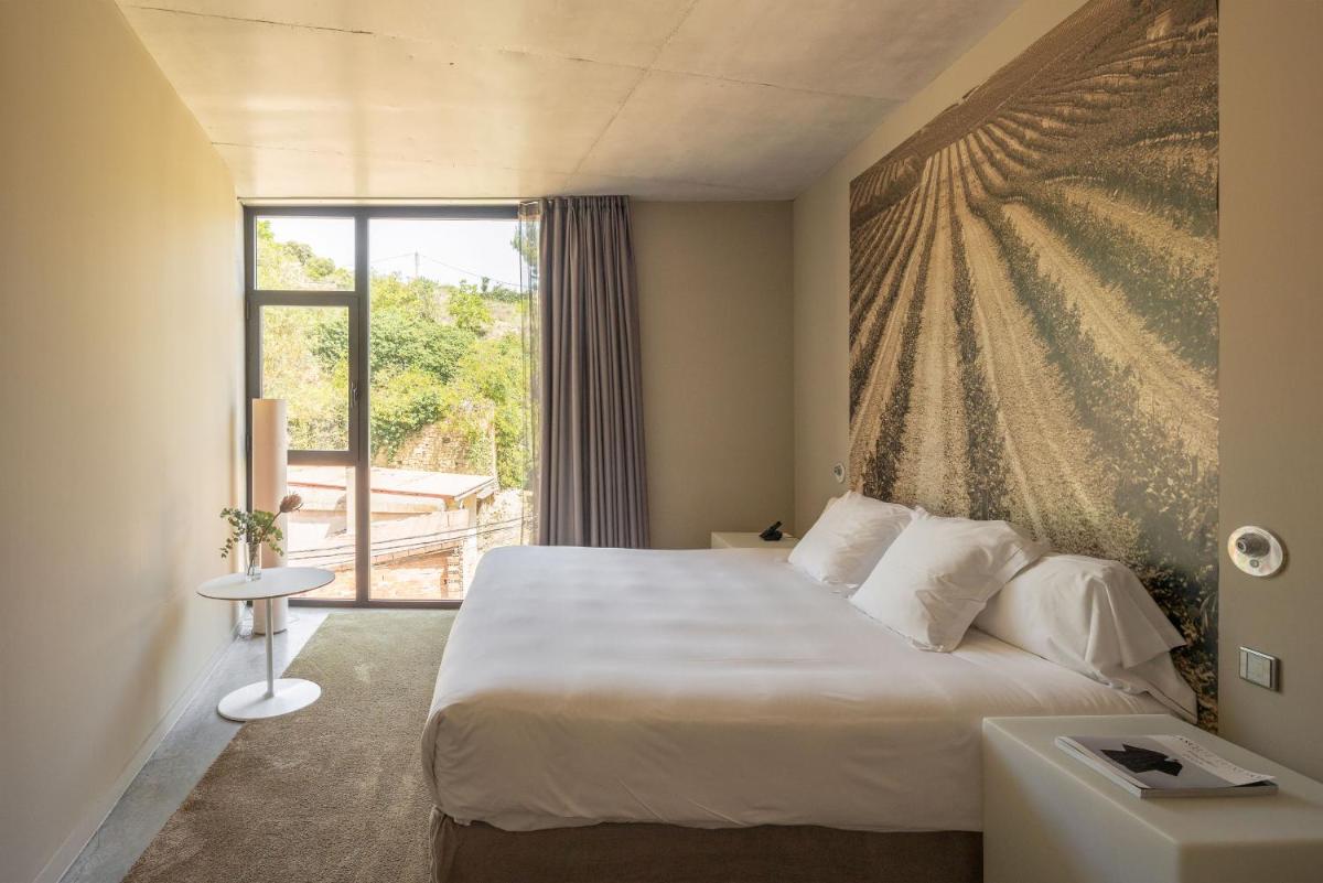 Una habitación de hotel con una cama y una ventana. en Hotel Viura, en Villabuena de Álava