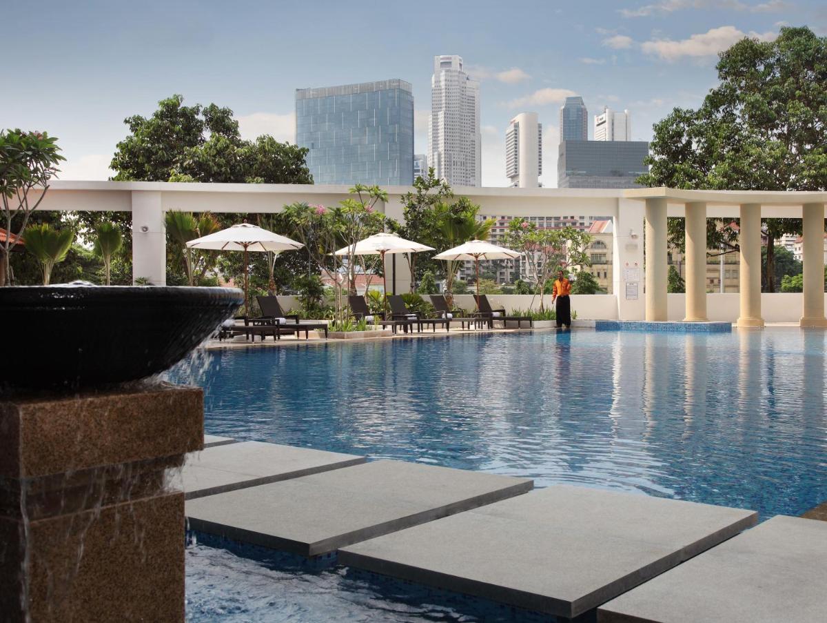 a swimming pool with chairs and umbrellas in a building at The Robertson House by The Crest Collection in Singapore a swimming pool with chairs and umbrellas in a building at The Robertson House by The Crest Collection in Singapore