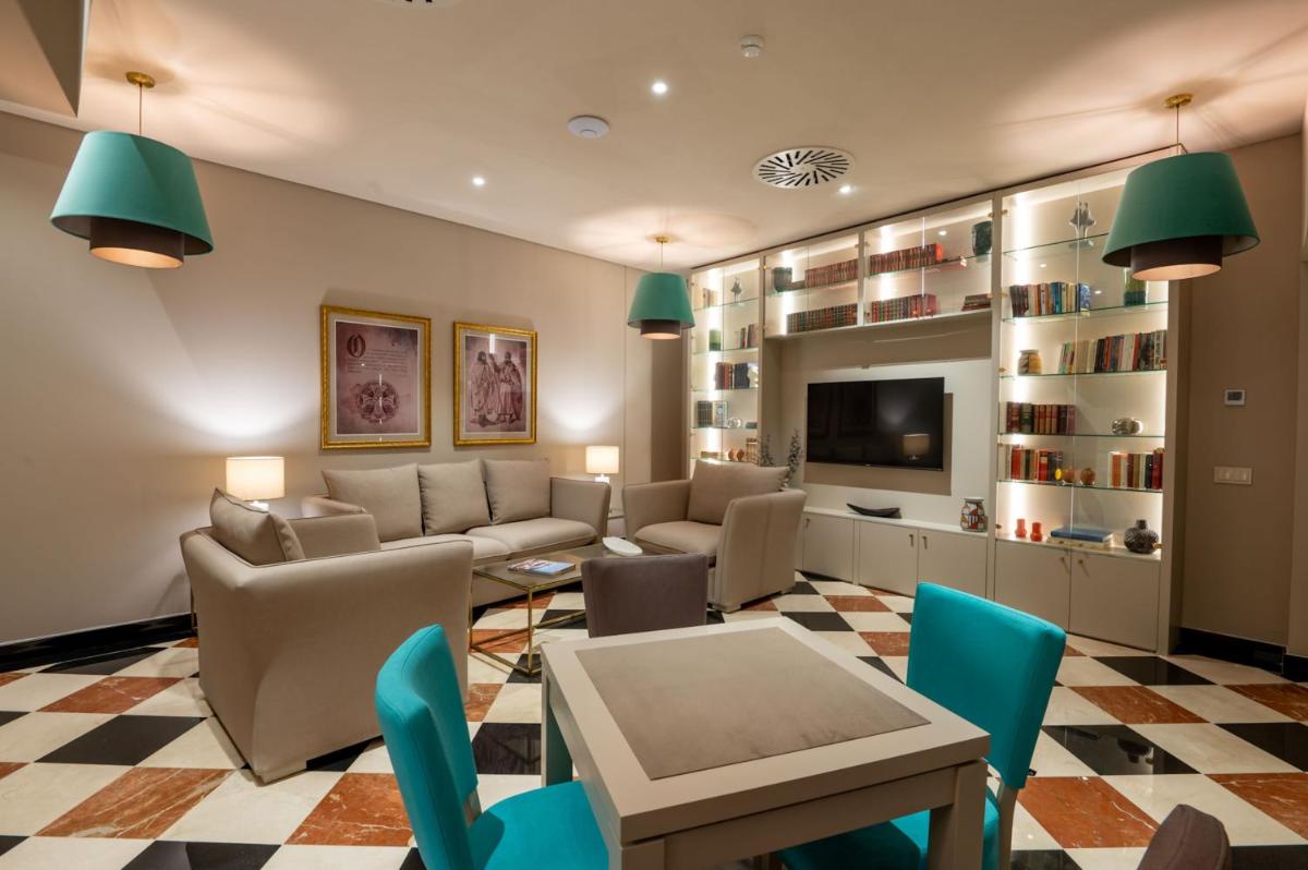 uma sala de estar com um sofá, uma mesa e cadeiras em Vila Gale Collection Tomar em Tomar