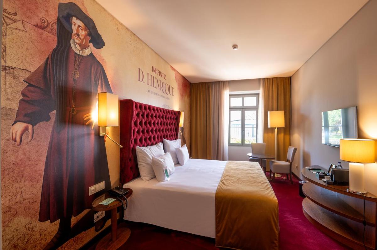 um quarto de hotel com uma cama com um quadro na parede em Vila Gale Collection Tomar em Tomar