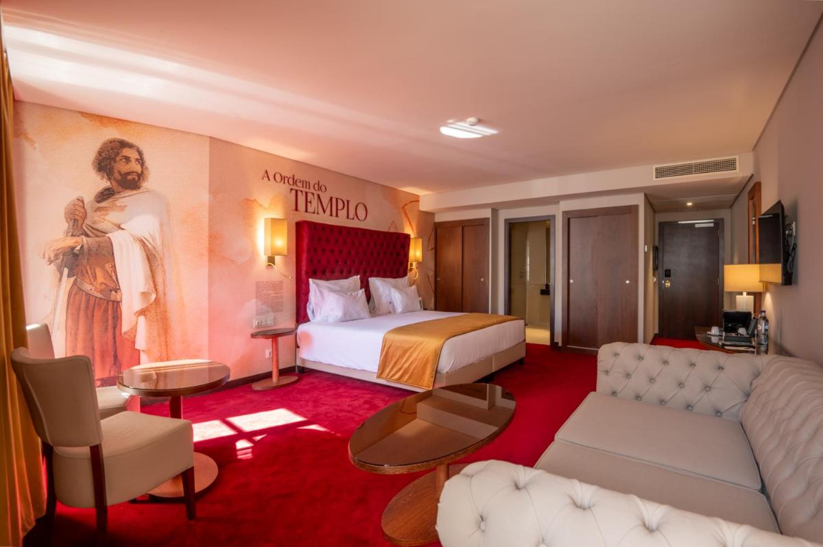 um quarto de hotel com uma cama king-size e uma sala de estar em Vila Gale Collection Tomar em Tomar mais 63 fotografias