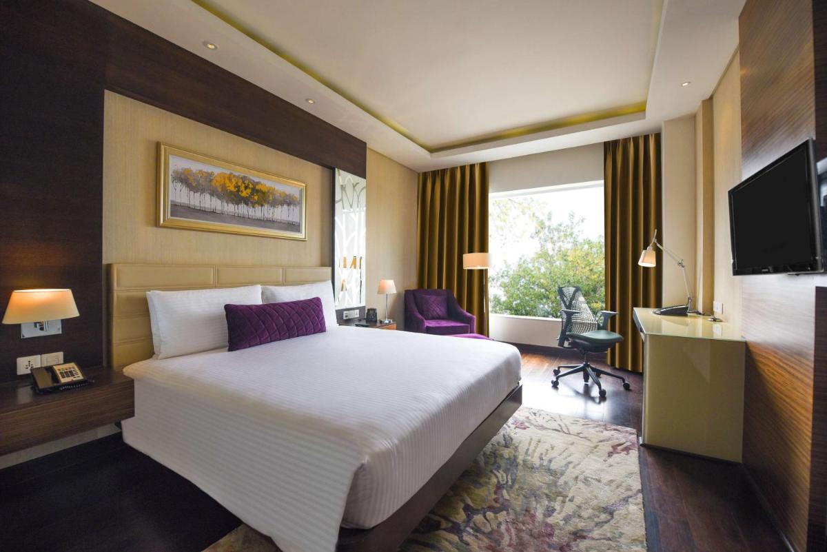 a hotel room with a bed and a television at DoubleTree by Hilton Gurugram Baani Square in Gurgaon
