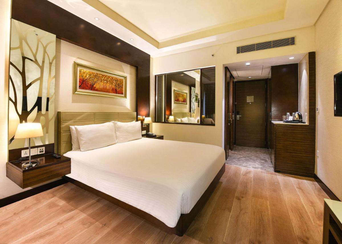 a bedroom with a large white bed and a bathroom at DoubleTree by Hilton Gurugram Baani Square in Gurgaon
