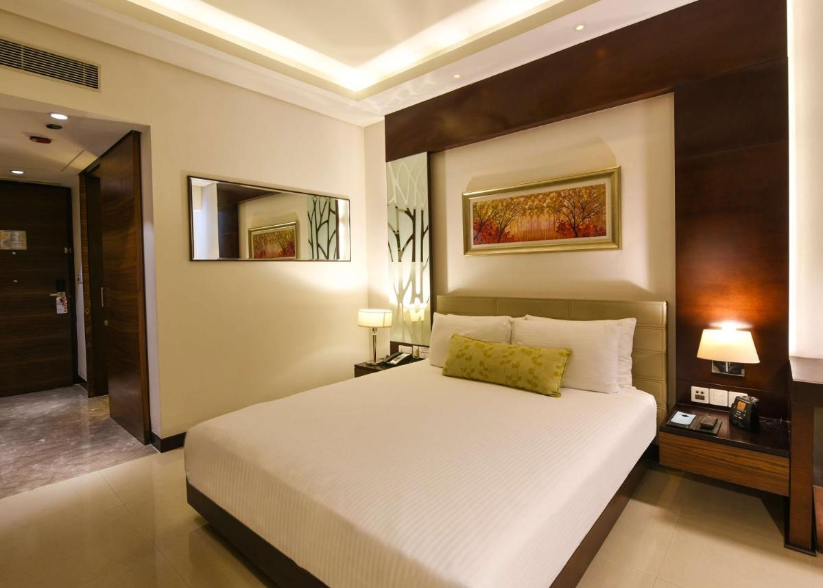 a bedroom with a large white bed and two lamps at DoubleTree by Hilton Gurugram Baani Square in Gurgaon