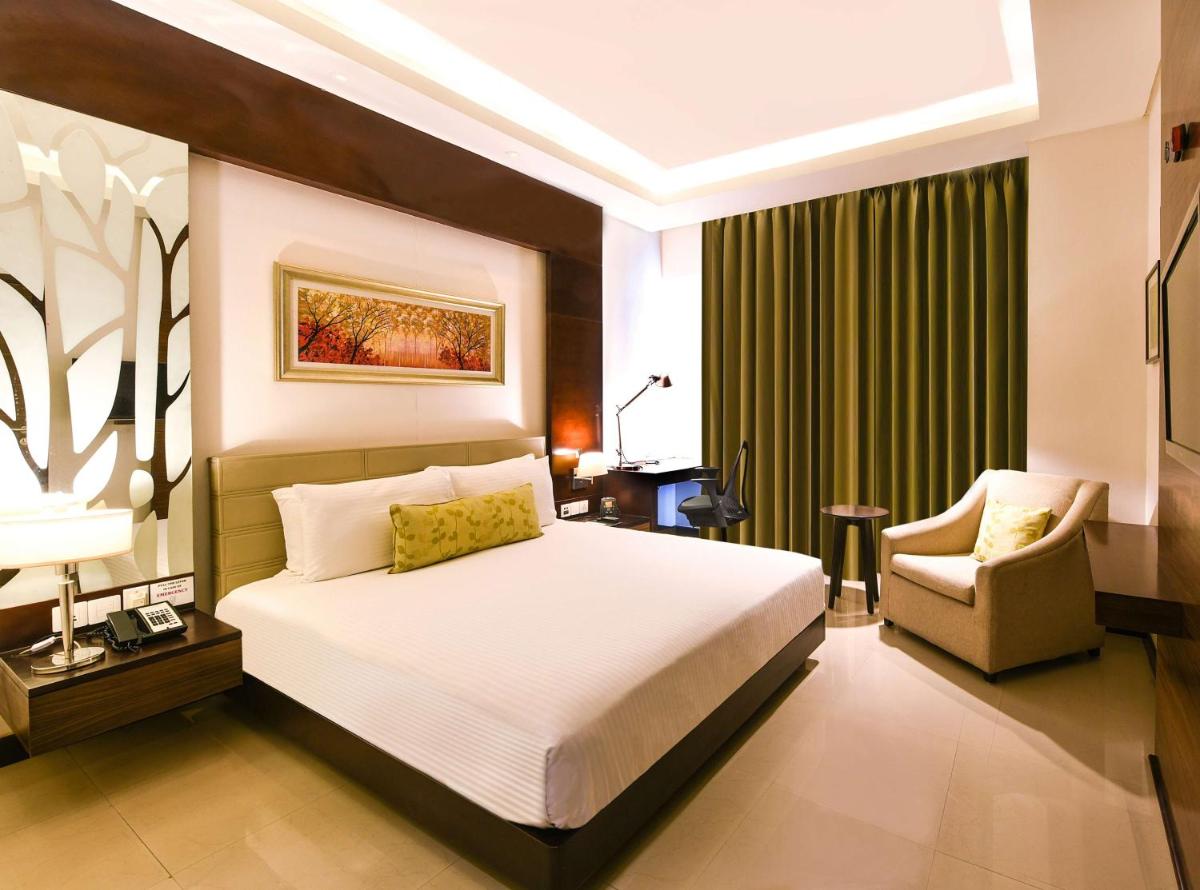 a hotel room with a bed and a chair at DoubleTree by Hilton Gurugram Baani Square in Gurgaon