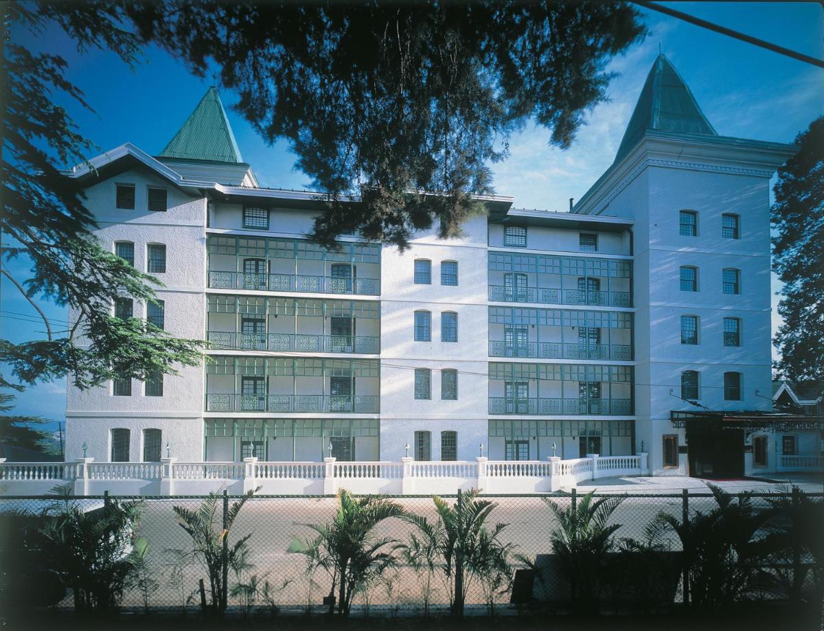 a large white building with two pointed roofs at The Oberoi Cecil in Shimla