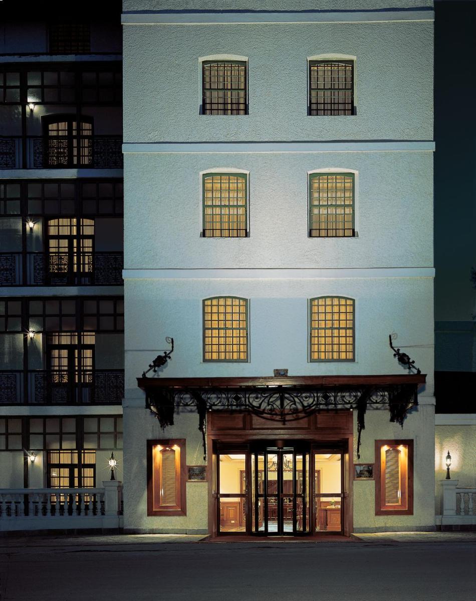a large white building with windows and doors at night at The Oberoi Cecil in Shimla