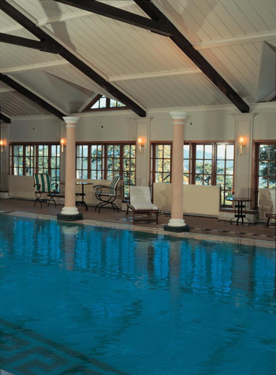 a large swimming pool in a building with windows at The Oberoi Cecil in Shimla