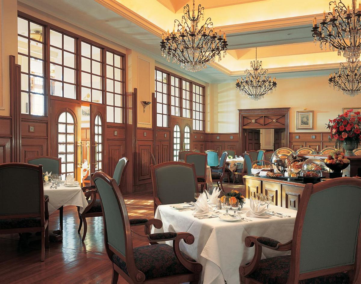 a dining room with tables and chairs and chandeliers at The Oberoi Cecil in Shimla