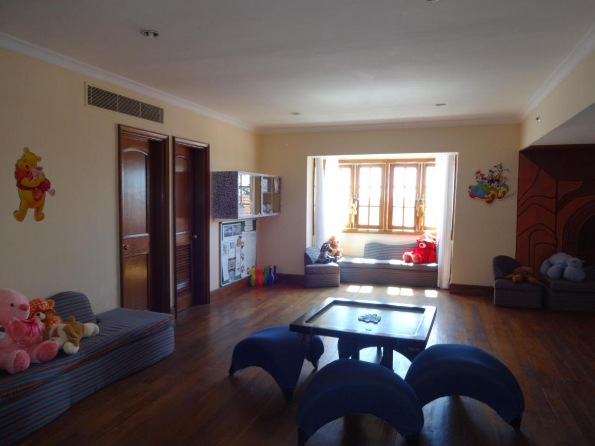 a living room with a table and a couch at The Oberoi Cecil in Shimla