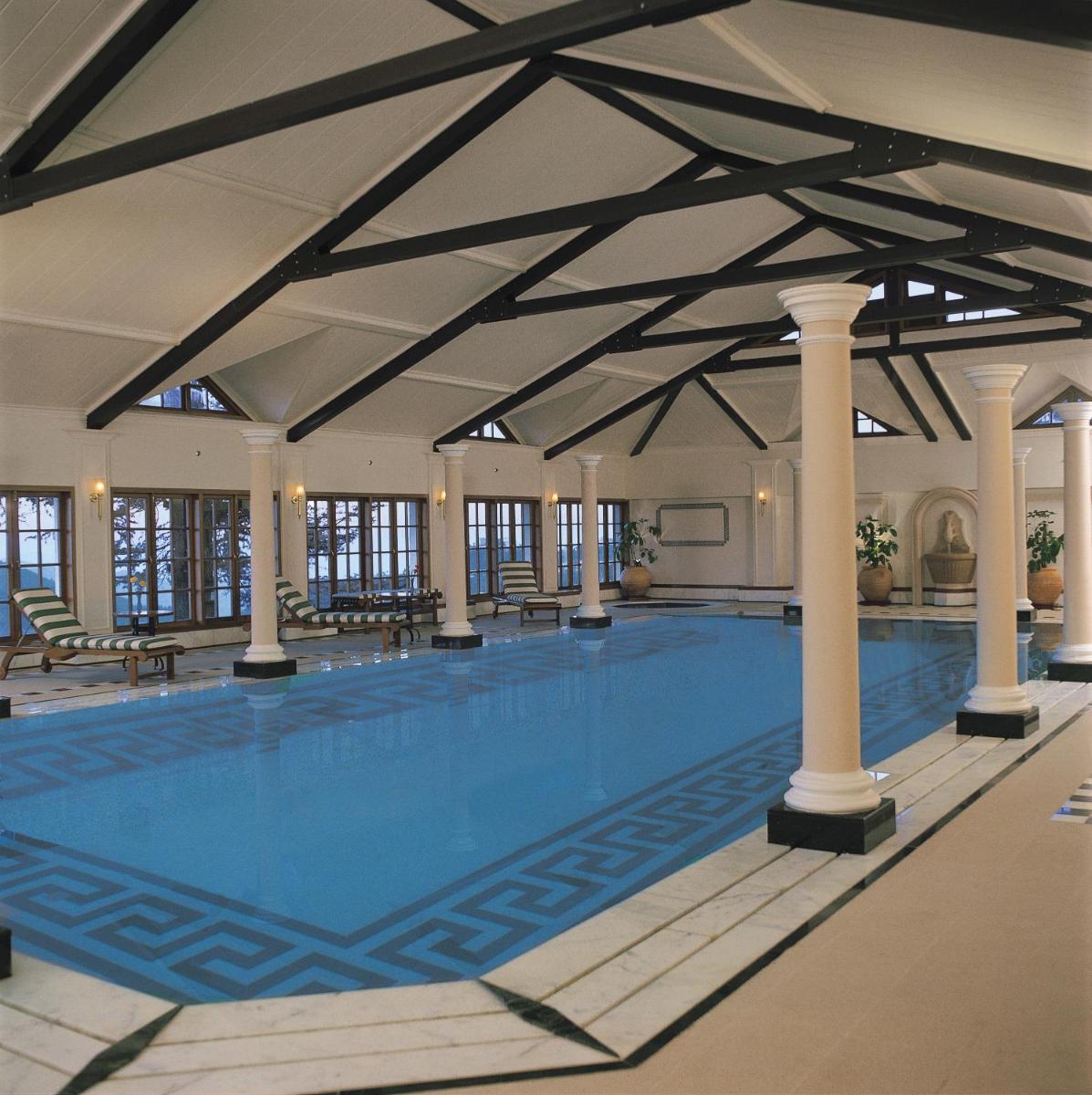a large swimming pool in a building with a large ceiling at The Oberoi Cecil in Shimla