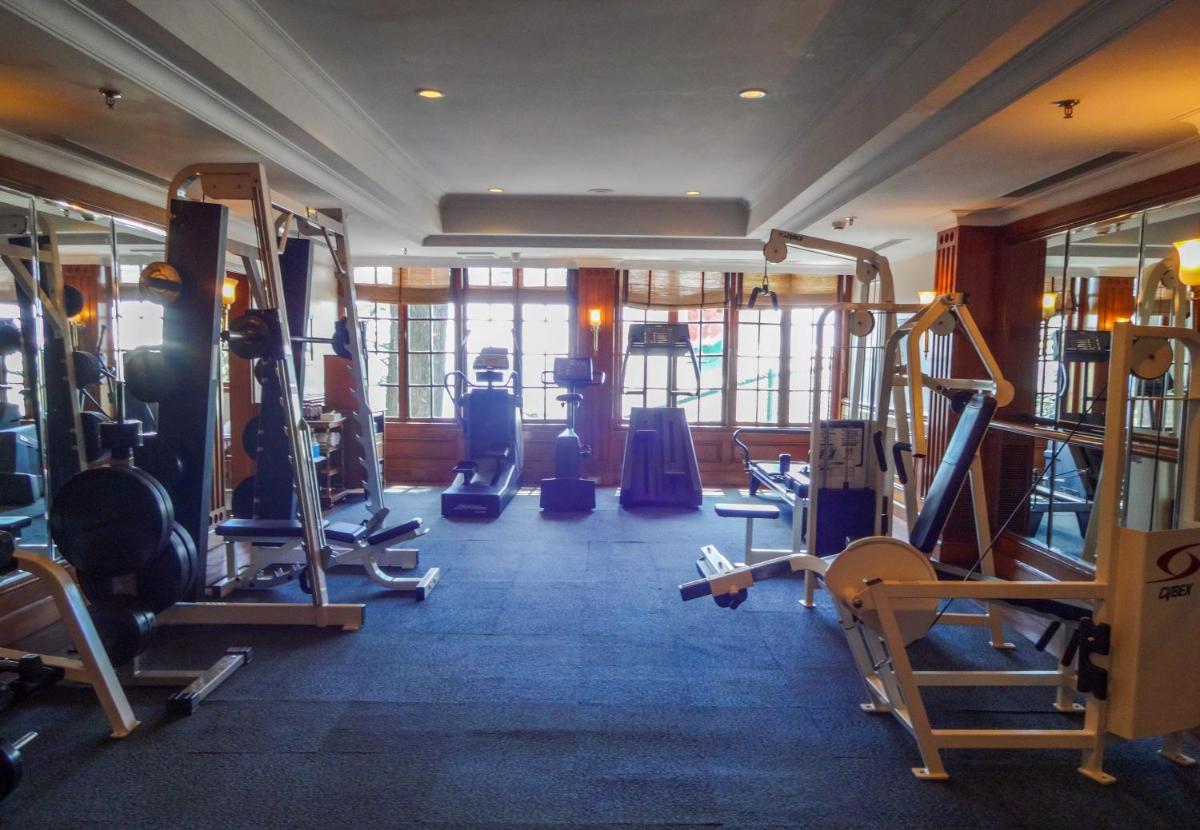 a gym with several tread machines in a room at The Oberoi Cecil in Shimla