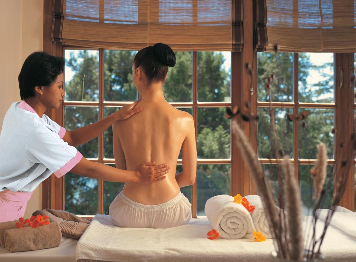a woman is getting a mans back in a room at The Oberoi Cecil in Shimla