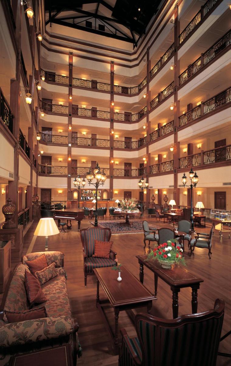 a large lobby with couches and tables in a building at The Oberoi Cecil in Shimla