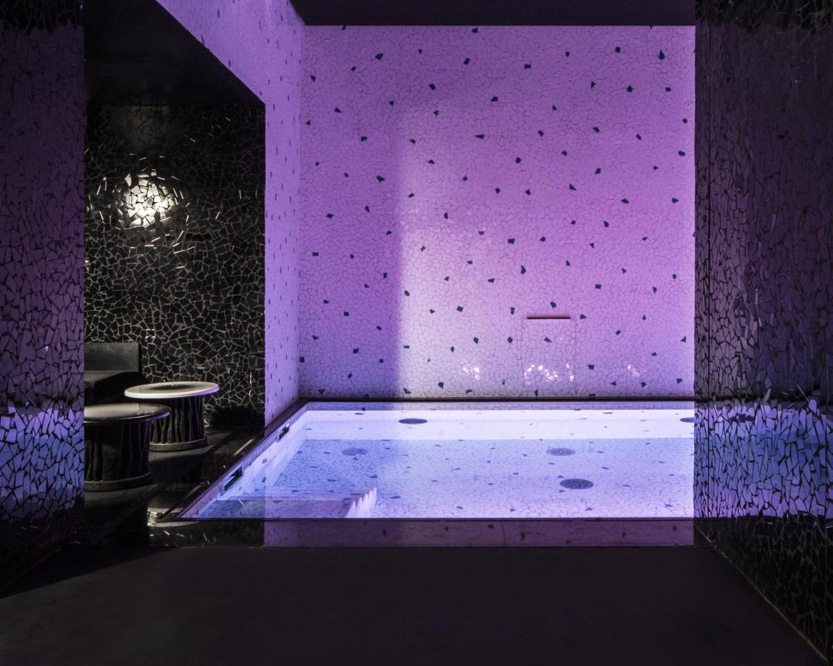 Cette chambre dispose d'une baignoire et d'un éclairage violet. dans l'établissement Hotel Les Bains Paris, à Paris