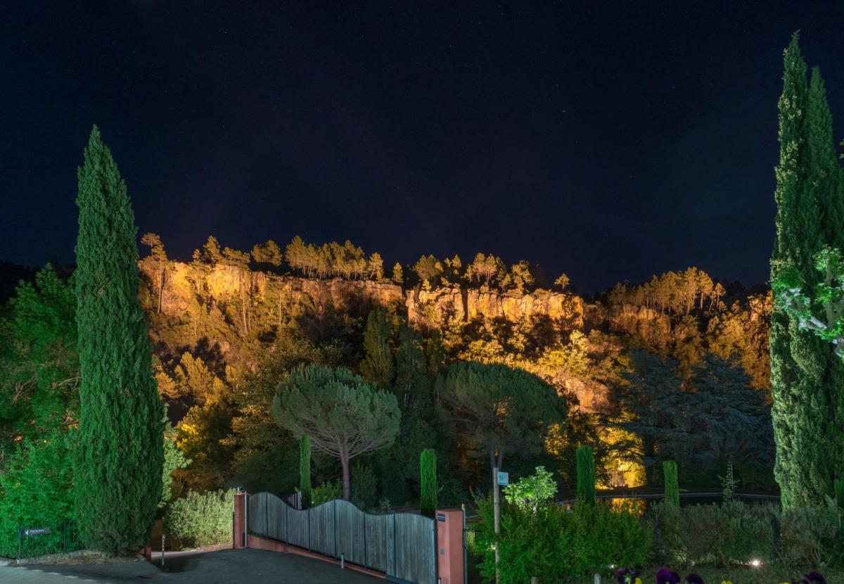 une montagne la nuit avec une clôture et des arbres dans l'établissement Hostellerie Les Gorges De Pennafort, à Callas