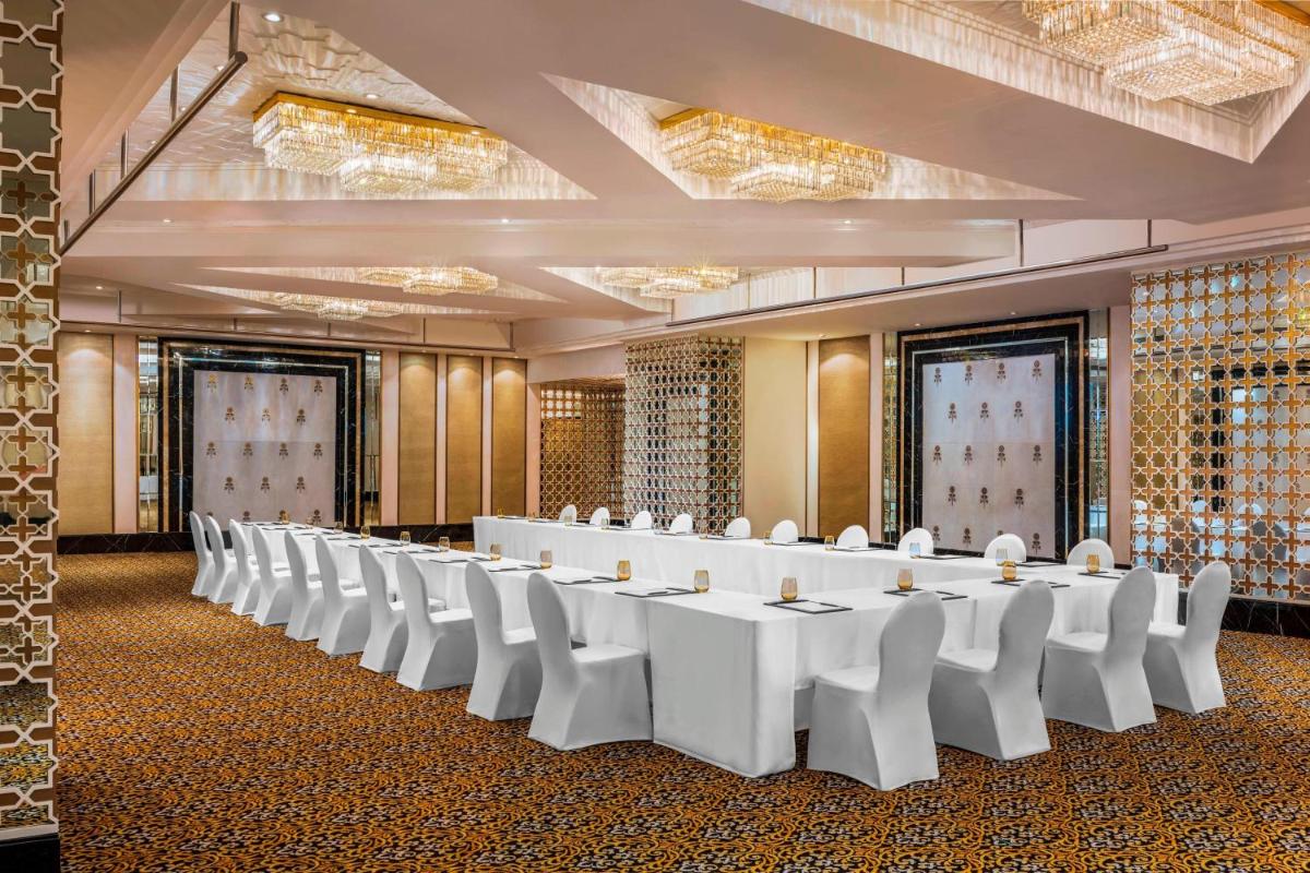 a large room with white tables and white chairs at The St. Regis Mumbai in Mumbai