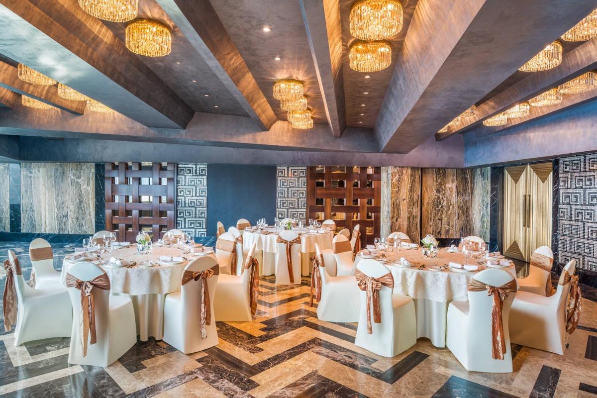 a banquet room with tables and chairs and lights at The St. Regis Mumbai in Mumbai