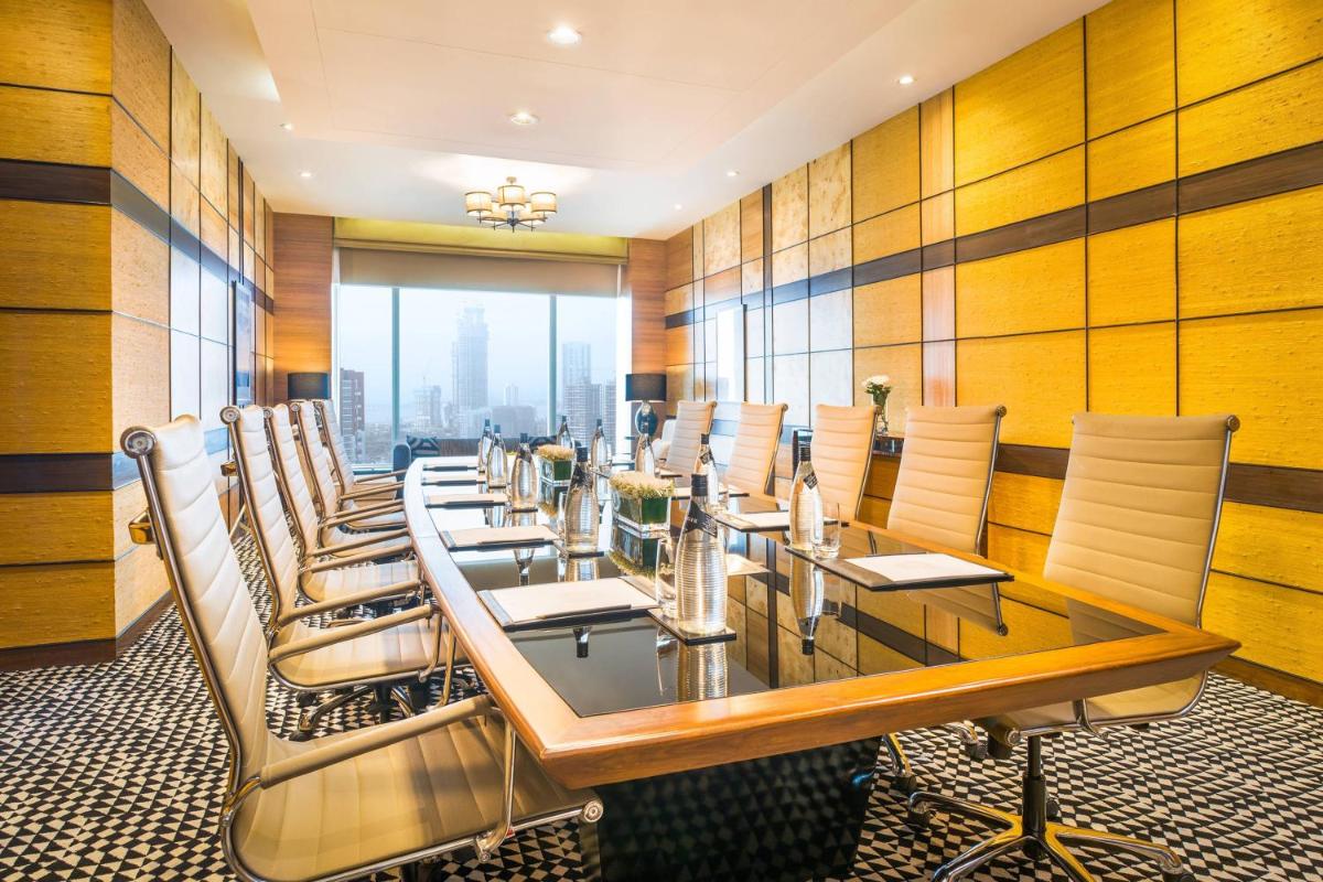 a dining room with a long table and chairs at The St. Regis Mumbai in Mumbai