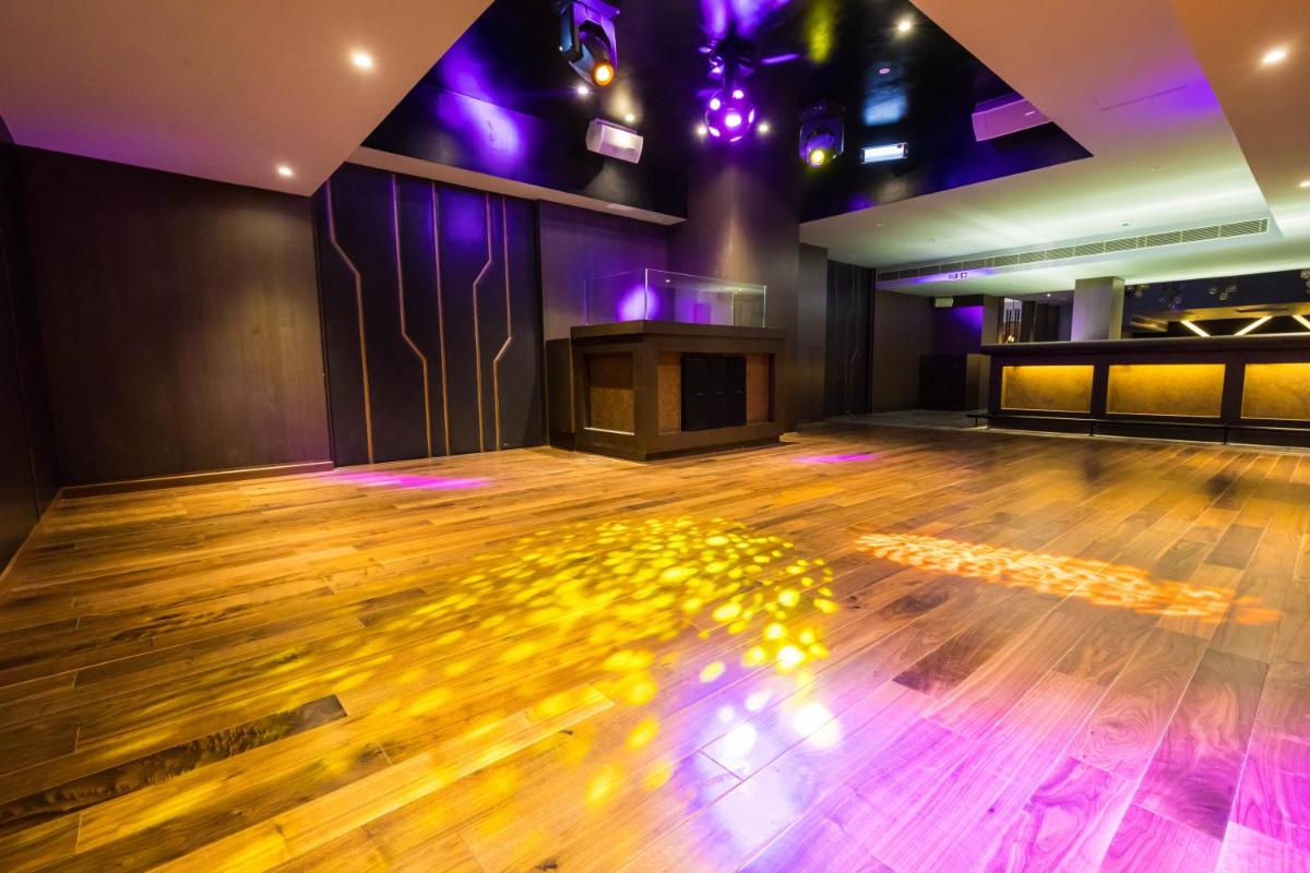 a room with a wooden floor and purple lights at Ramada by Wyndham Lucknow Hotel and Convention Center in Lucknow