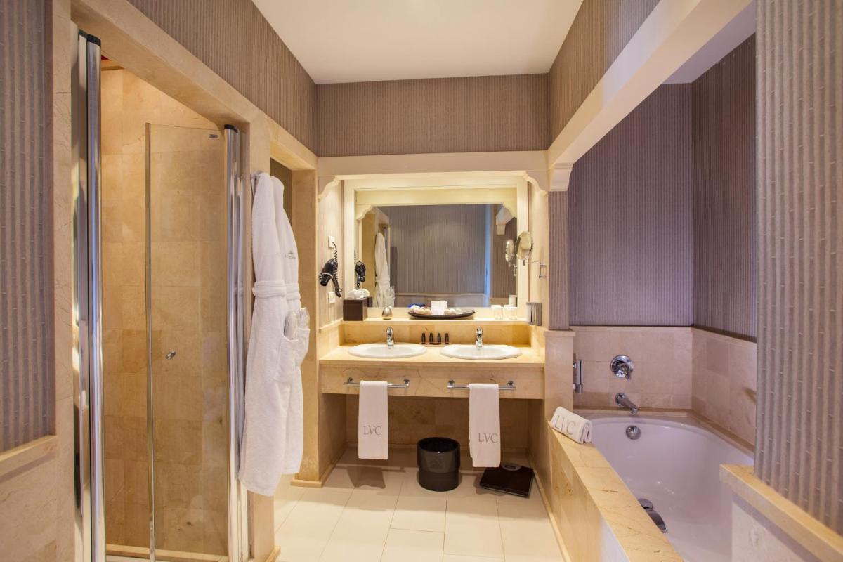 Un baño con dos lavabos y una bañera. en Lopesan Villa del Conde Resort & Thalasso, en Meloneras