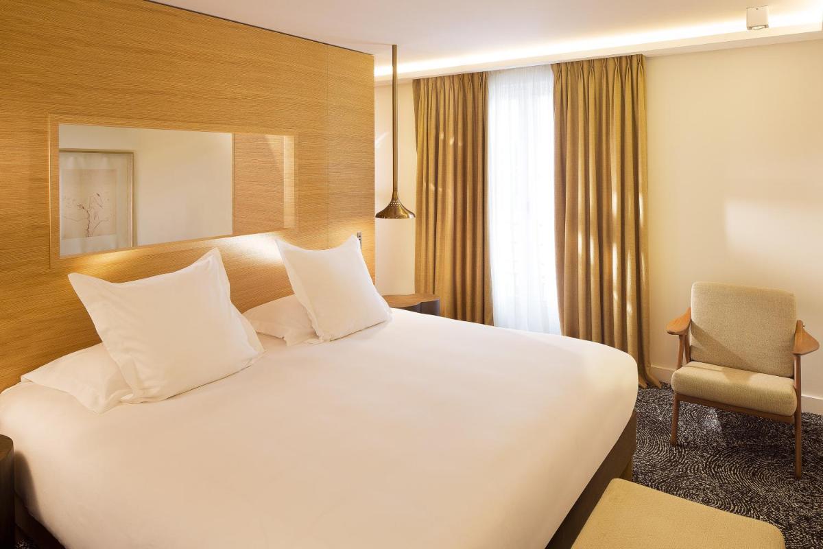 Un ou plusieurs lits dans un hébergement de l'établissement Hotel Marignan Champs-Elysées