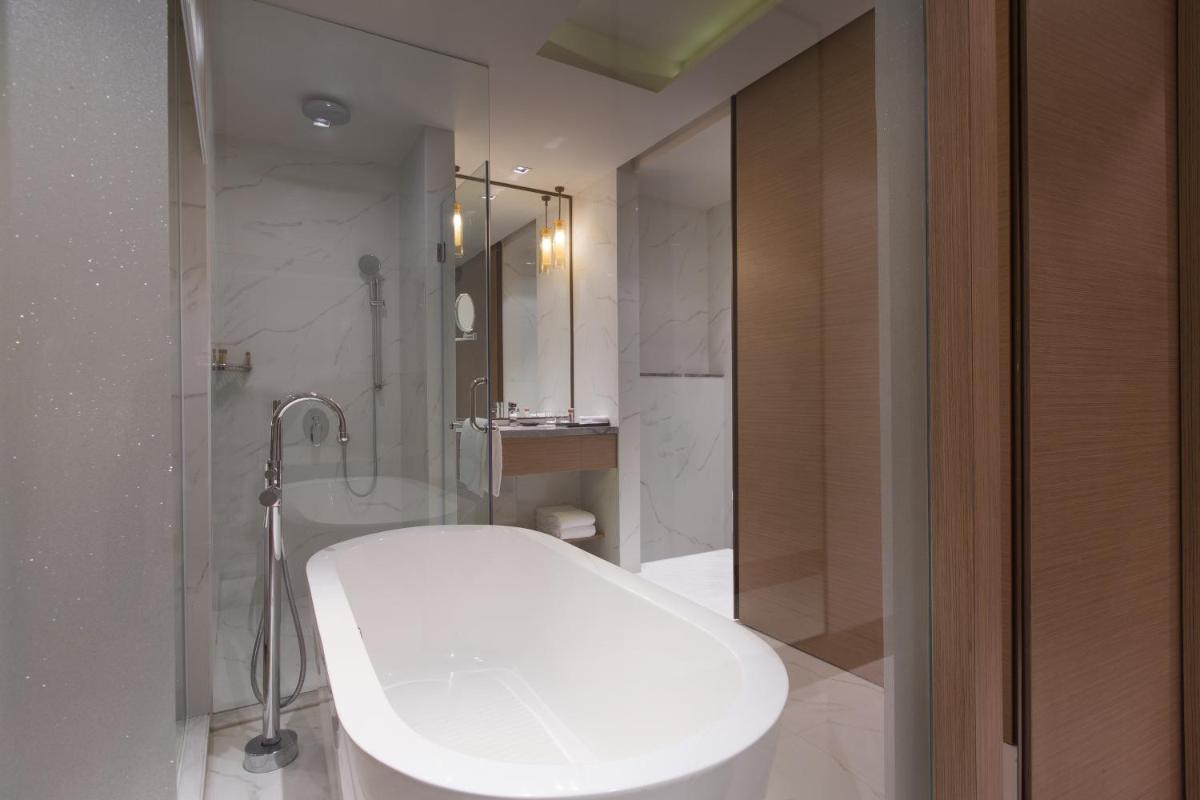 a bathroom with a white tub and a shower at Sheraton Hyderabad Hotel in Hyderabad