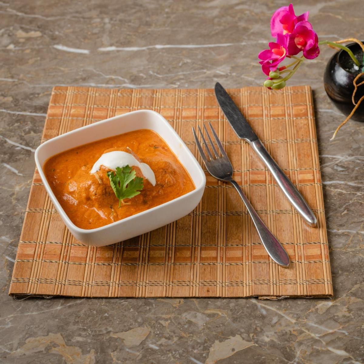 a bowl of soup on a napkin with a fork and knife at Southern Star,Mysore in Mysore