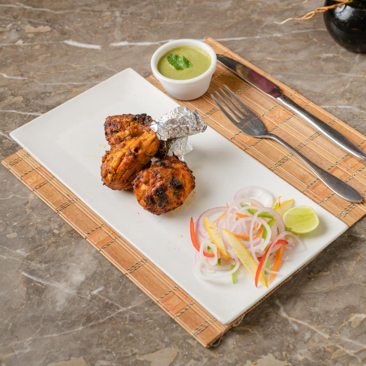 a plate of food with meat and vegetables on a table at Southern Star,Mysore in Mysore