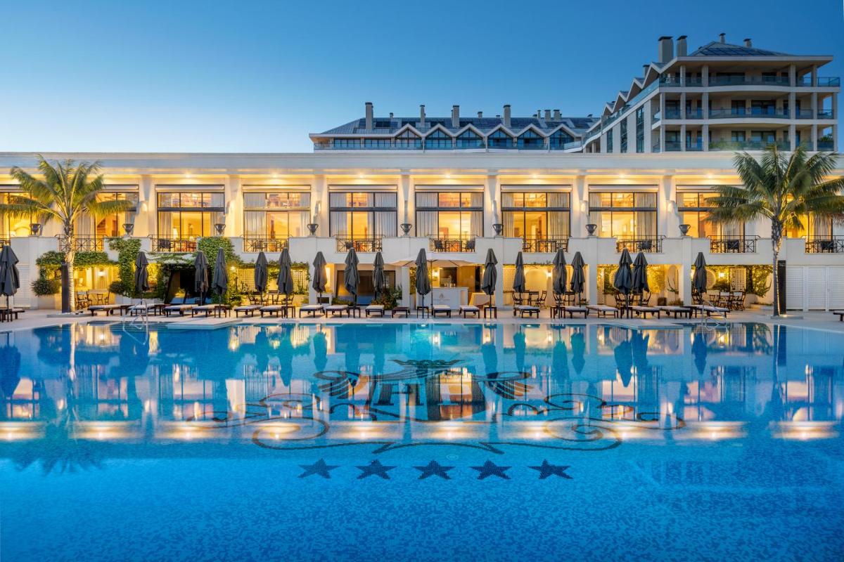 uma grande piscina em frente a um hotel em Palácio Estoril Hotel, Golf & Wellness em Estoril