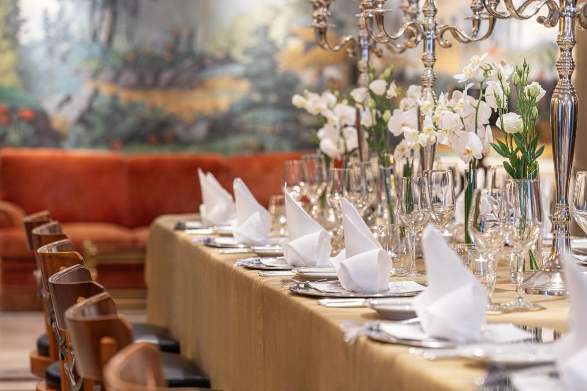 uma mesa longa com guardanapos brancos e flores em Palácio Estoril Hotel, Golf & Wellness em Estoril mais 109 fotografias