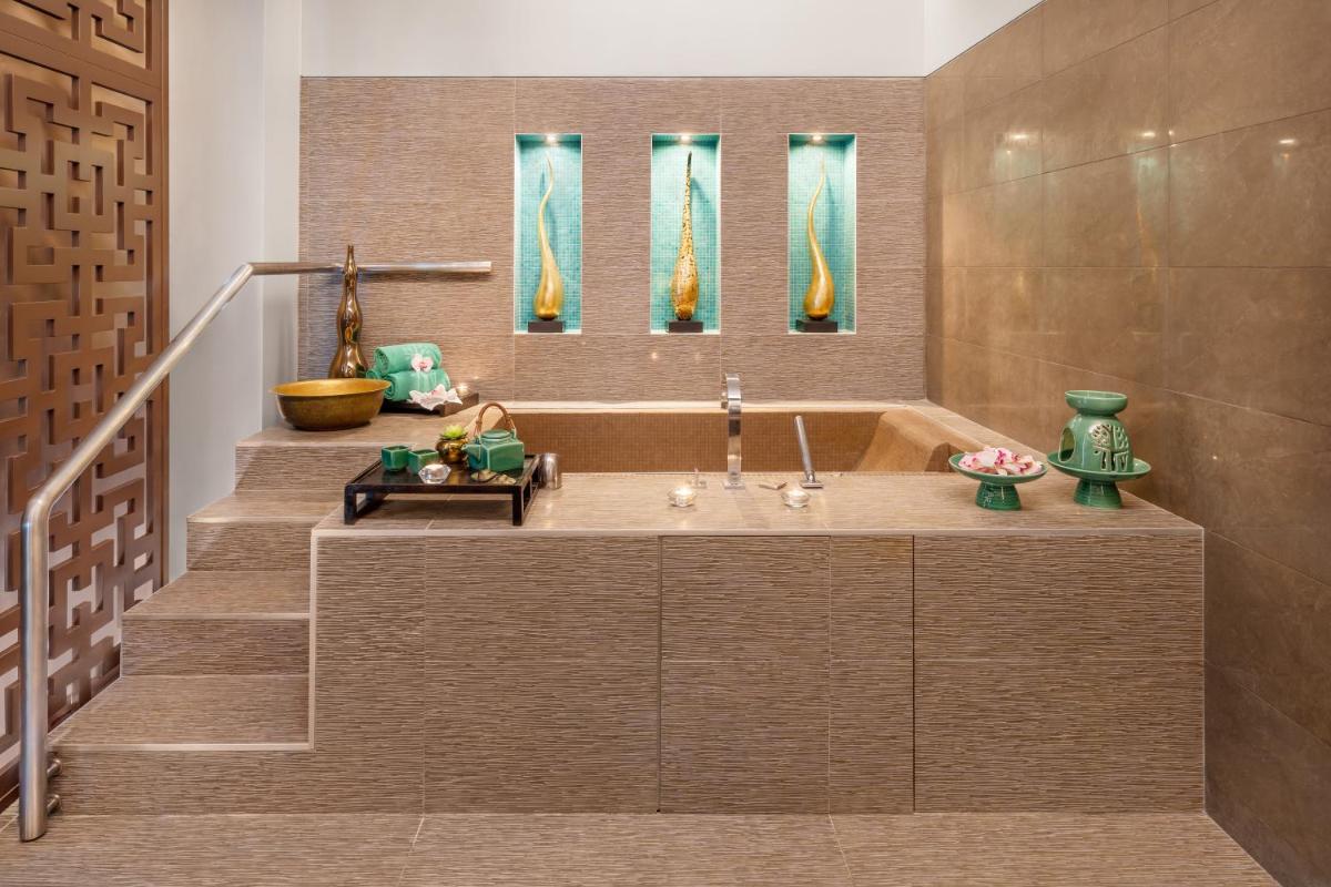 uma casa de banho com uma banheira e uma escada em Palácio Estoril Hotel, Golf & Wellness em Estoril