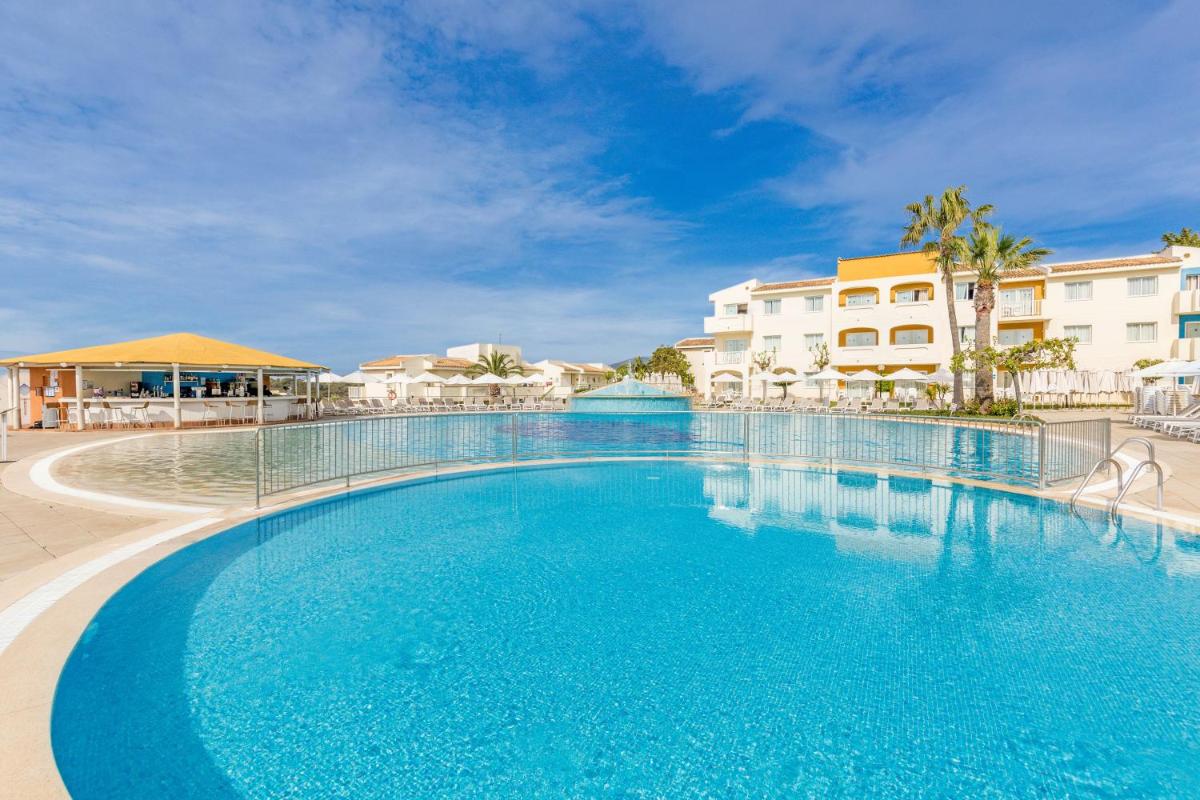 una piscina en un resort con agua azul en Blau Punta Reina, en Cala Mendia