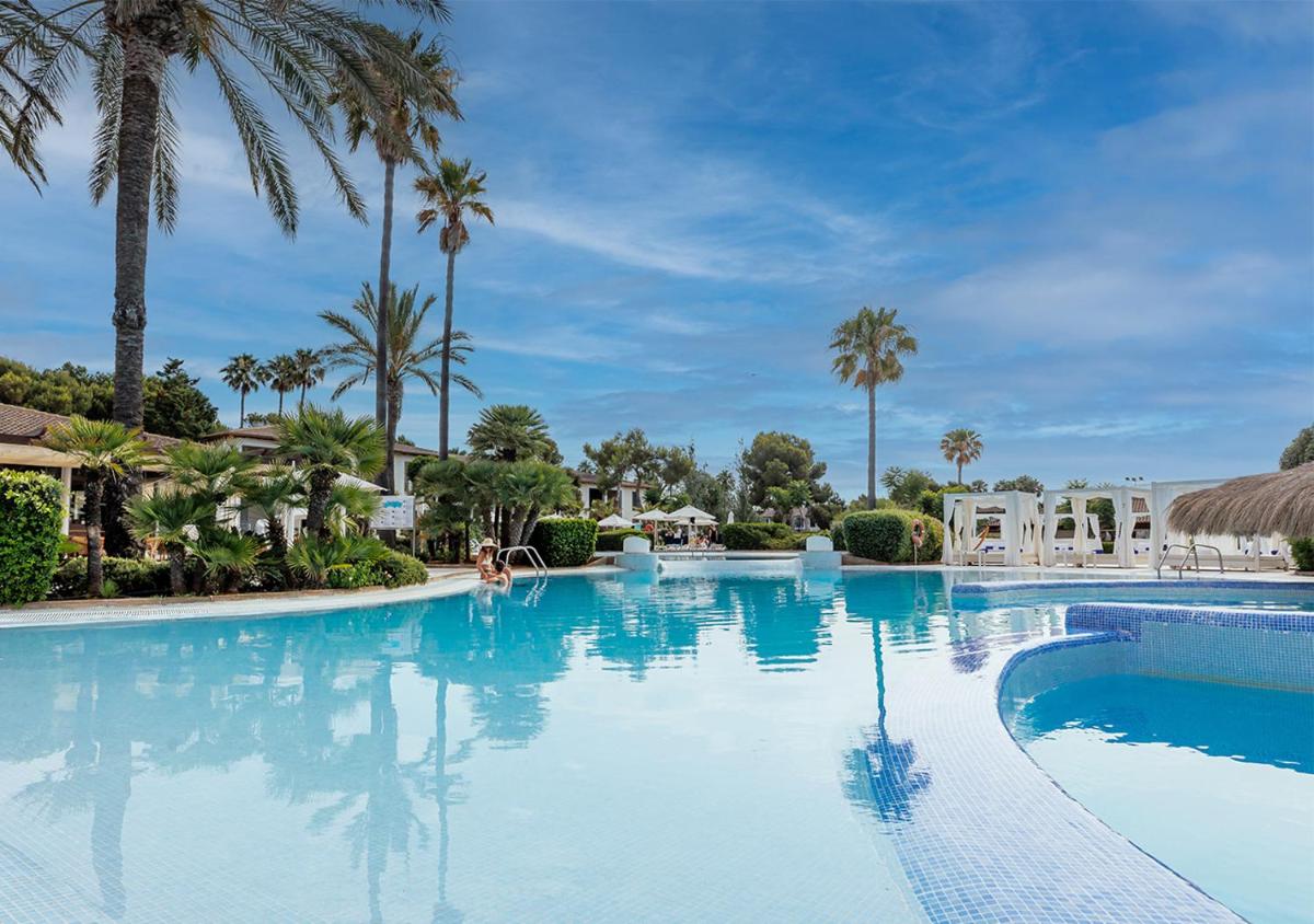 una piscina en un resort con palmeras en Blau Colònia Sant Jordi, en Colonia de Sant Jordi