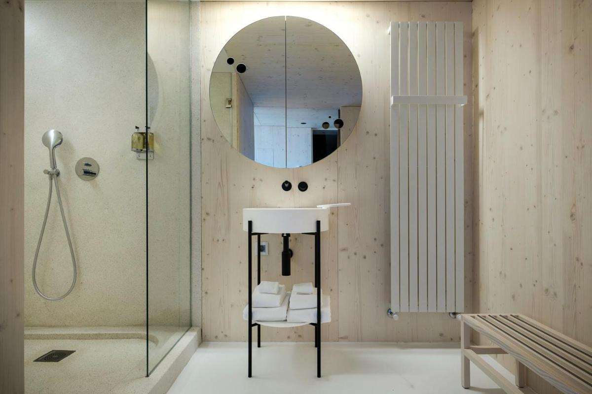 uma casa de banho com uma cabina de duche em vidro e um espelho. em Casa de São Lourenço - Burel Panorama Hotel - member of Design Hotels em Manteigas