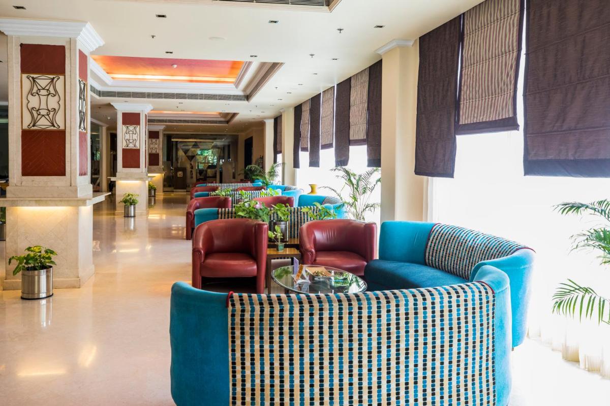 a lobby with couches and chairs in a building at The Piccadily in Lucknow