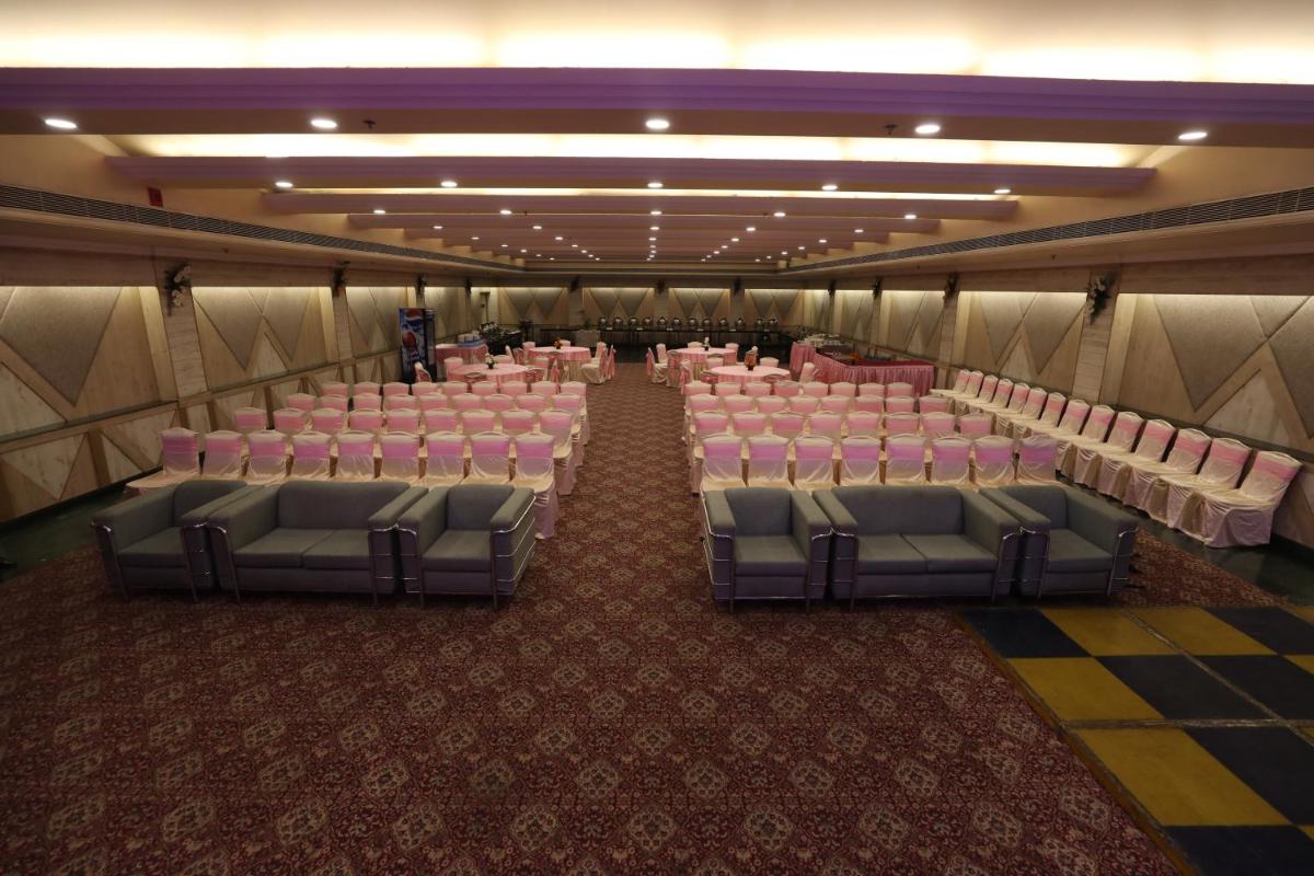 a banquet hall with pink chairs and pink tables at The Piccadily in Lucknow
