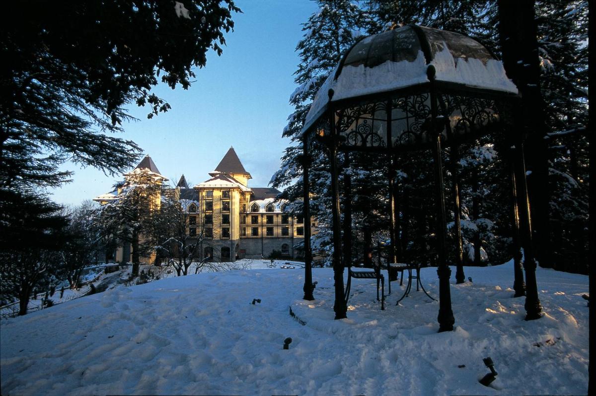 a building with a gazebo in the snow at Wildflower Hall, An Oberoi Resort, Shimla in Shimla