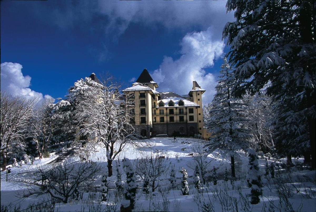 a large building on top of a snow covered hill at Wildflower Hall, An Oberoi Resort, Shimla in Shimla