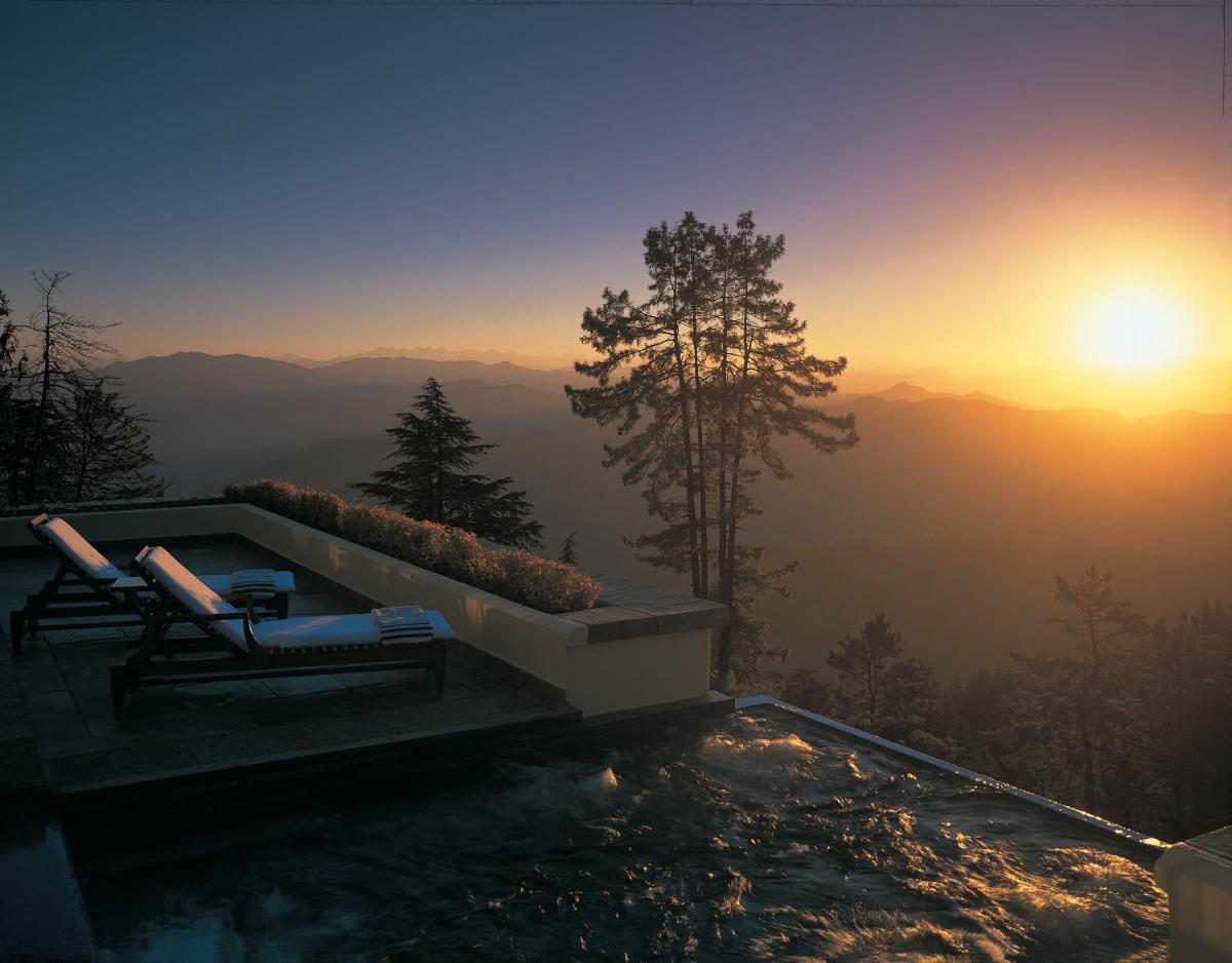 a swimming pool with a view of the mountains at Wildflower Hall, An Oberoi Resort, Shimla in Shimla